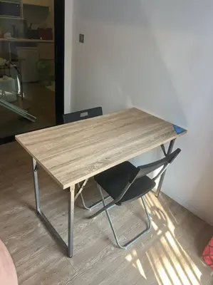 a wooden table with a chair in a room at Great Value Apartment in Bang Khen