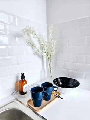 a kitchen counter with three blue cups on a tray at Midtown Duplex Ratchayothin in Bangkok