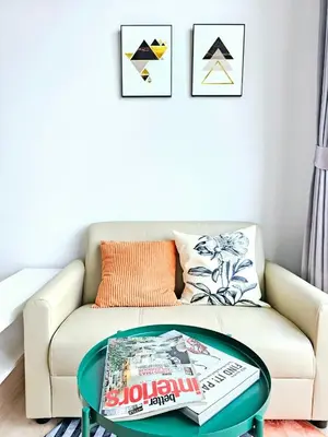 a living room with a couch with a coffee table at Midtown Duplex Ratchayothin in Bangkok