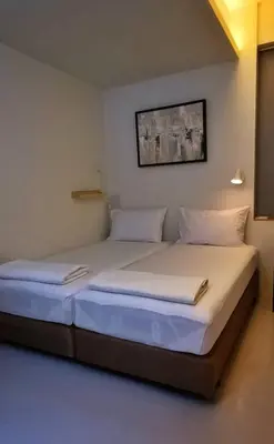 a bedroom with two beds with white sheets at Hello my friend in Bang Bua Thong Railway Station