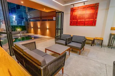 a room with chairs and a table and a pool at Hello my friend in Bang Bua Thong Railway Station
