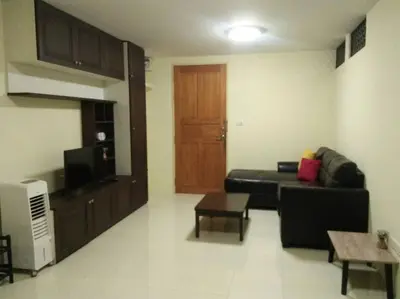 a living room with a black couch and a table at Cozy 1 Bedroom Apartment Close by Ratchada in Bangkok
