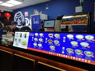 a counter in a fast food restaurant with people preparing food at Cozy 1 Bedroom Apartment Close by Ratchada in Bangkok