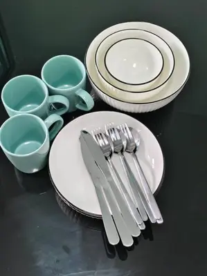 a table with plates and utensils on a table at Fully Furnished Apartment Close to MRT Pool n Gym in Nonthaburi
