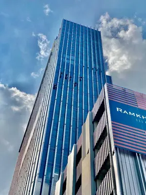 a tall glass building with a sign on it at The Quarter Ramkhamhaeng by UHG in Bangkok