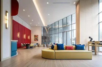 a living room with a yellow couch in a lobby at The Quarter Ramkhamhaeng by UHG in Bangkok