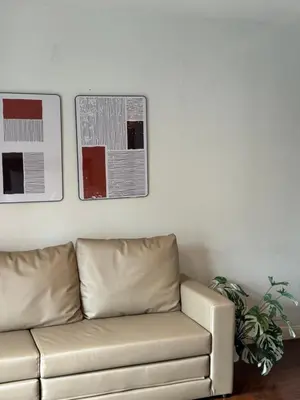 a couch in a living room with two pictures on the wall at Entire Townhome 3BR3B, Pool, Sukhumvit-EmSphere in Bangkok