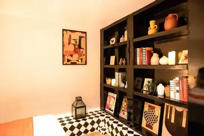 a living room with a book shelf with books at Best river view - Loft apartment in great location in Bangkok