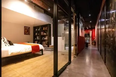 a bedroom with a bed and a glass wall at Best river view - Loft apartment in great location in Bangkok