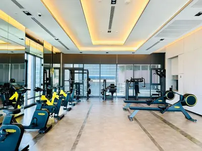a gym with a row of treadmills and machines at The Address Siam Luxury Two Bedrooms in Bangkok