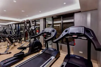 a gym with several tread machines in a row at BTS Thonglor - Serene Japanese-style Haven, Onsen in Bangkok