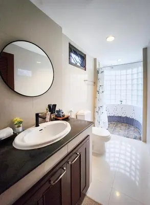 a bathroom with a sink and a toilet and a mirror at Asokes Hidden Gem Cozy Stay Next to the Park in Bangkok