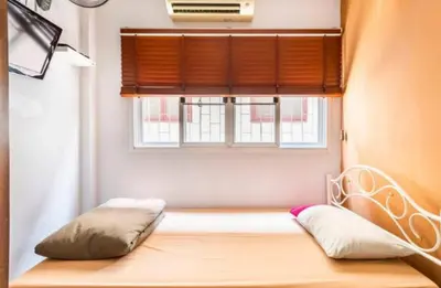 a room with a window with a bed and a pillow at 1137 Hostel in Bangkok