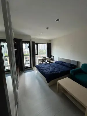 a bedroom with a blue bed and a couch at Thong Lor, Sukhumvit 36 in Bangkok