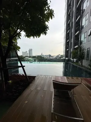 a wooden deck with a bench in front of a building at Thong Lor, Sukhumvit 36 in Bangkok