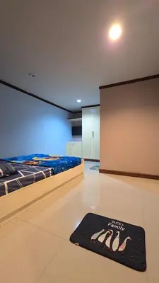 a room with a bed and a rug on the floor at The Haven Sabi in Bangkok
