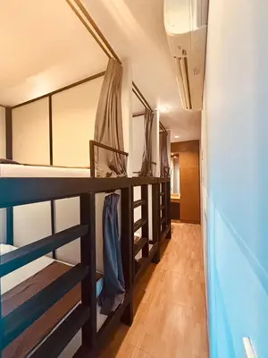 a room with three bunk beds and a hallway at The LODGE BKK Hostel in Bangkok