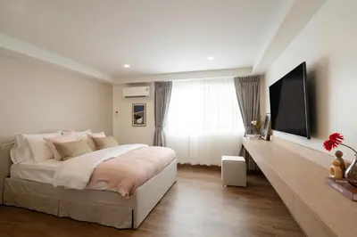 a bedroom with a large bed and a flat screen tv at Naiya Bangkok in Bangkok