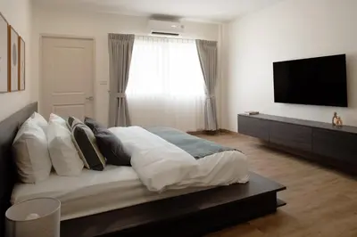 a bedroom with a large bed with a flat screen tv at Naiya Bangkok in Bangkok
