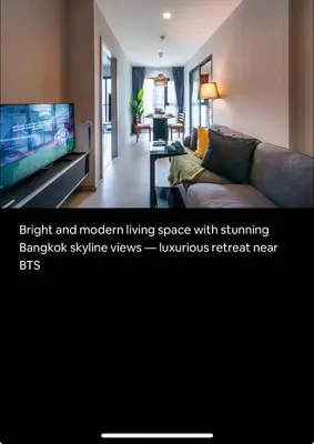 a living room with a couch and a flat screen tv at Cozy Apartment With Train Access in Bangkok