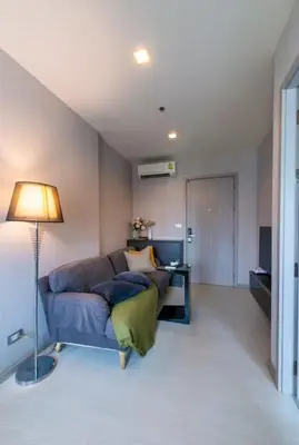 a living room with a blue couch and a lamp at Luxurious Upscale Downtown Apartment in Bangkok