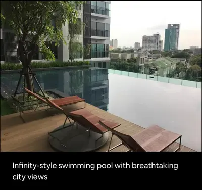 an infinity style swimming pool with a table and chairs at Luxurious Upscale Downtown Apartment in Bangkok