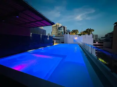 a swimming pool on the roof of a building at night at 6th Avenue Sukhumvit BKK 308 BTS Asoke & Nana MRT Sukhumvit in Bang Kapi