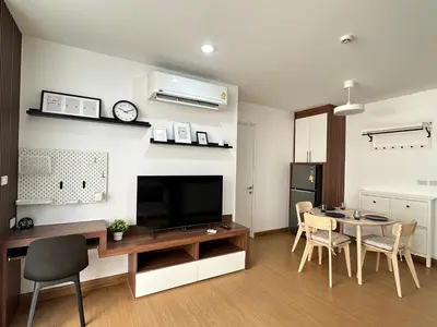 a living room with a dining table and a television at 6th Avenue Sukhumvit 305 BTS Asoke & Nana MRT Sukhumvit in Bang Kapi