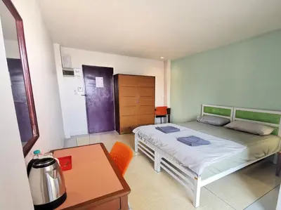 a small bedroom with a bed and a table at R Lodge in Bangkok