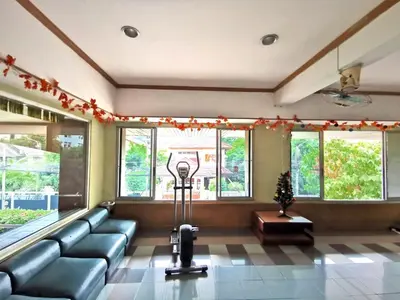 a waiting room with a couch and a fan at R Lodge in Bangkok