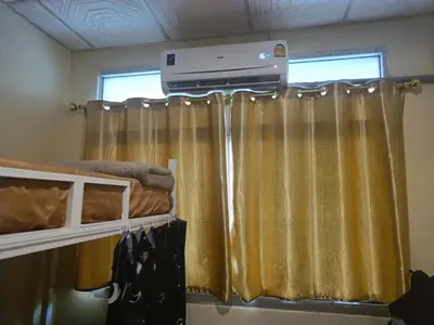 a bedroom with a bed and a window with curtains at The House Hostel 2 in Bangkok