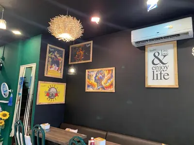a dining room with a black wall with pictures on it at The House Hostel 2 in Bangkok