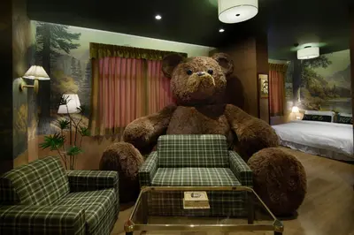 a large teddy bear sitting in a hotel room at Kitsch Hotel in Bangkok