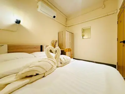 a bedroom with a bed with towels on it at Charming Hostel in Bangkok