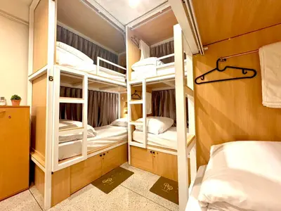 a room with three bunk beds in a room at Charming Hostel in Bangkok