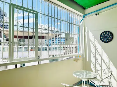 a balcony with a chair and a view of an airport at Charming Hostel in Bangkok
