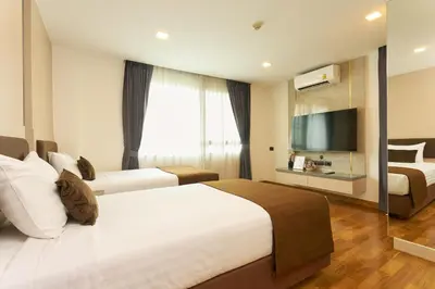a hotel room with two beds and a flat screen tv at Shine Aparthotels Sukhumvit Thonglor in Bangkok