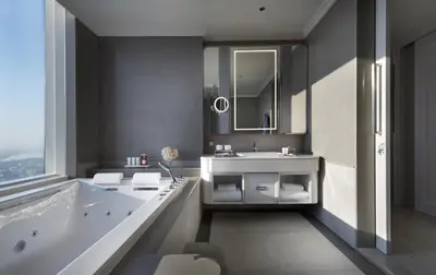 a bathroom with a tub and a sink and a mirror at Grande Centre Point Lumphini Bangkok in Bangkok