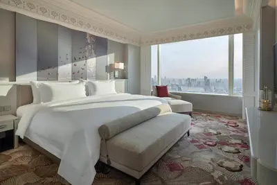 a bedroom with a large white bed and a large window at Grande Centre Point Lumphini Bangkok in Bangkok