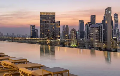 a view of a city skyline with tables and chairs at Grande Centre Point Lumphini Bangkok in Bangkok