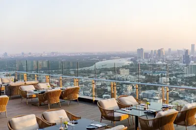 a restaurant with tables and chairs and a view of a city at Grande Centre Point Lumphini Bangkok in Bangkok