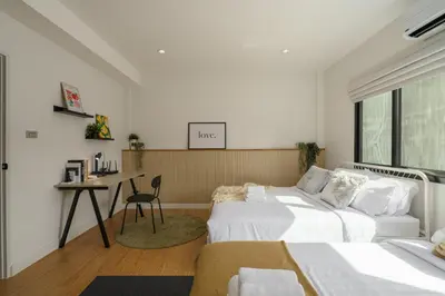 a bedroom with two beds and a desk in it at Cozy Spacious 4BR Villa, 12pax, 200m BTS PhraKhanong, 10min ThongLo, Fast 500mbps Wifi in Bangkok