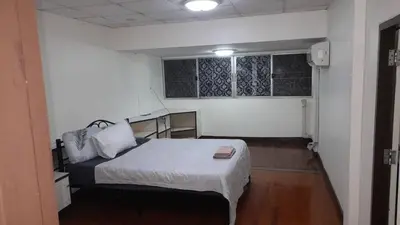a small bedroom with a bed and a window at Sirin Home in Bangkok