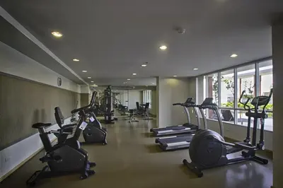 a gym with a row of treadmills and elliptical machines at Cozy Living in Bangkok 60m to MRT near chatuchank in Bang Su