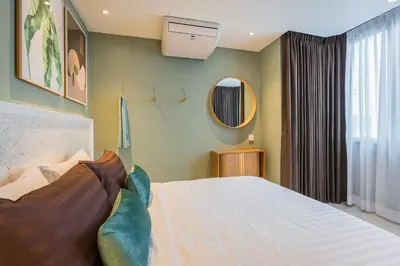 a bedroom with a bed and a mirror at PETRA Designer Apartment Sukhumvit, Nana BTS in Bangkok