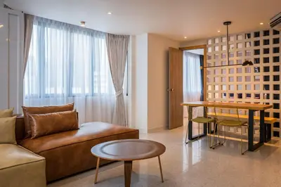 a living room with a couch and a table at PETRA Designer Apartment Sukhumvit, Nana BTS in Bangkok