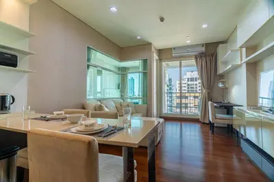 a kitchen and living room with a table and chairs at Thonglor area 1 Bedroom FastWiFi Sauna Big Swimming Pool 43 in Bangkok