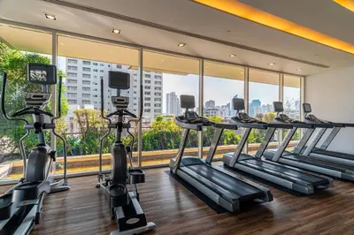 a gym with cardio machines and a large window at Thonglor Area 1 bedroom Check in 24h Fast WiFi 98 in Bangkok