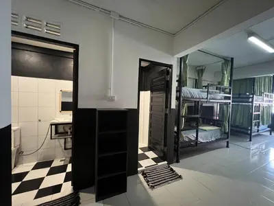 a room with two bunk beds and a bathroom at Years 1981 in Bangkok