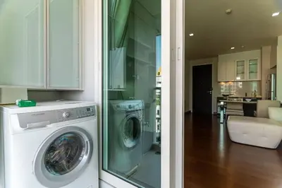 a kitchen and a living room with a washing machine at Thonglor area 1 Bedroom FastWiFi Sauna Big Swimming Pool 38 in Bangkok